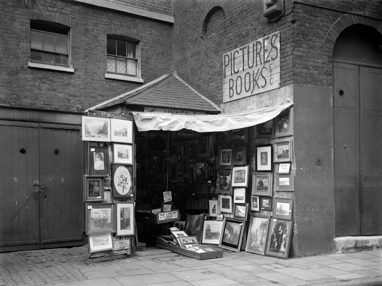 Fotos emolduradas exibidas do lado de fora de uma loja de livros e quadros de segunda mão, Londres, 1933. de WA Clark