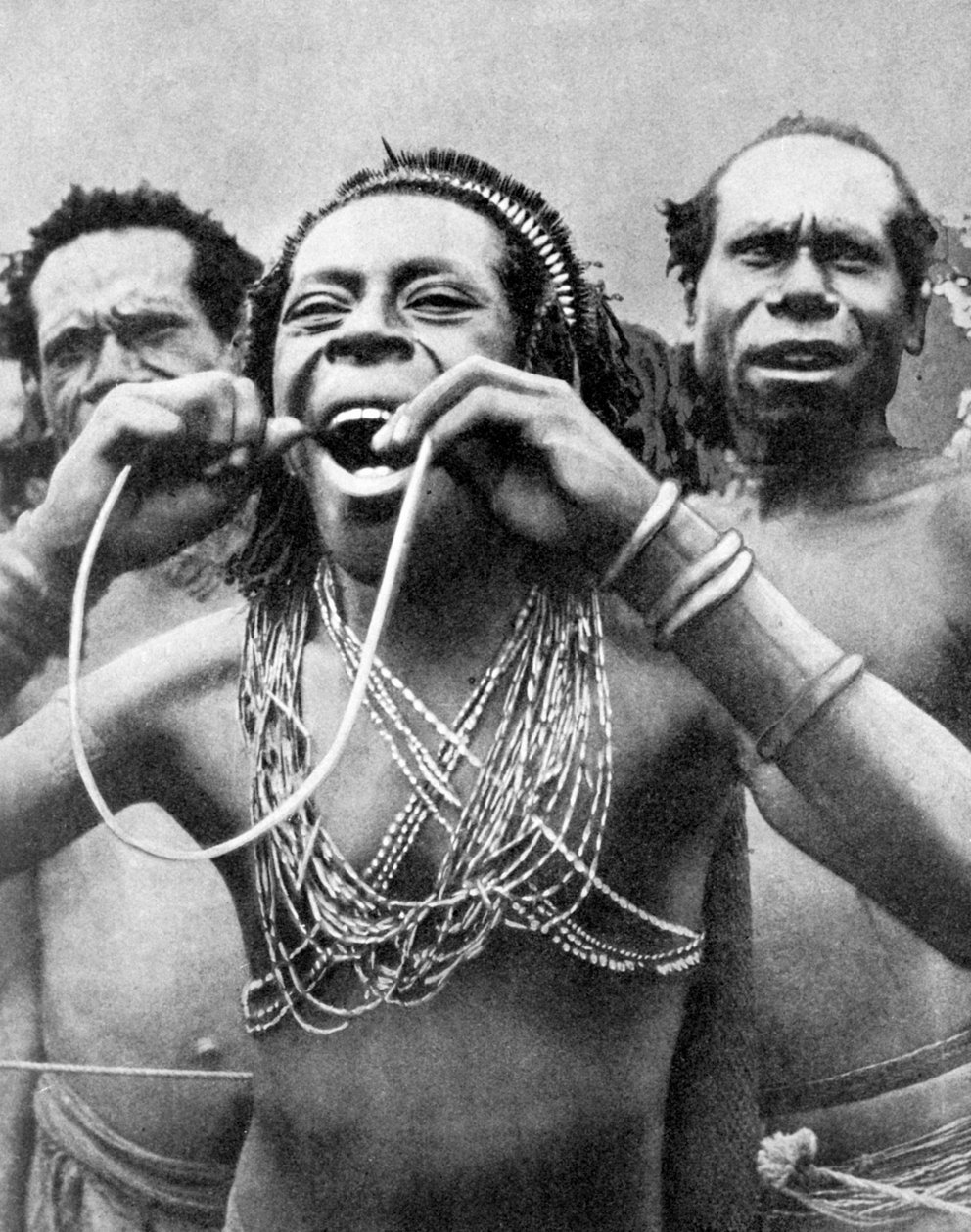 Engolir bengalas em um ritual cerimonial, Nova Guiné, 1936. de Wide World Photos