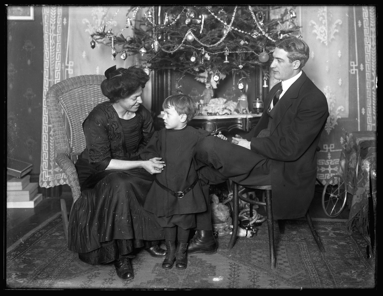 Dan Seymour e família em pose informal, sentado debaixo de uma árvore de Natal, Natal de 1912 de William Davis Hassler