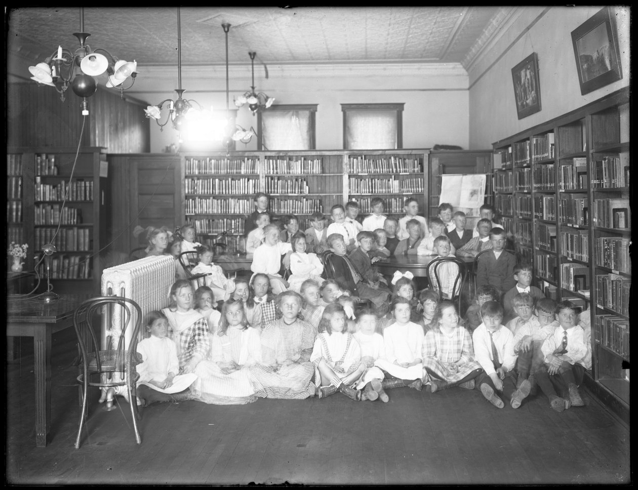 Retrato de grupo de crianças na sala de leitura de um ramo não identificado da Biblioteca Pública de Queens Borough, c.1910 de William Davis Hassler