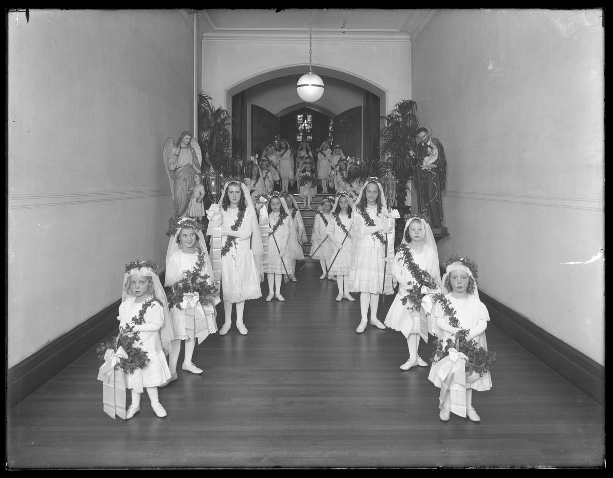 Garotinhas no asilo de católicos romanos, Kingsbridge, Bronx, voltando da capela em vestidos brancos com guirlandas e guirlandas, 20 de outubro de 1914 de William Davis Hassler