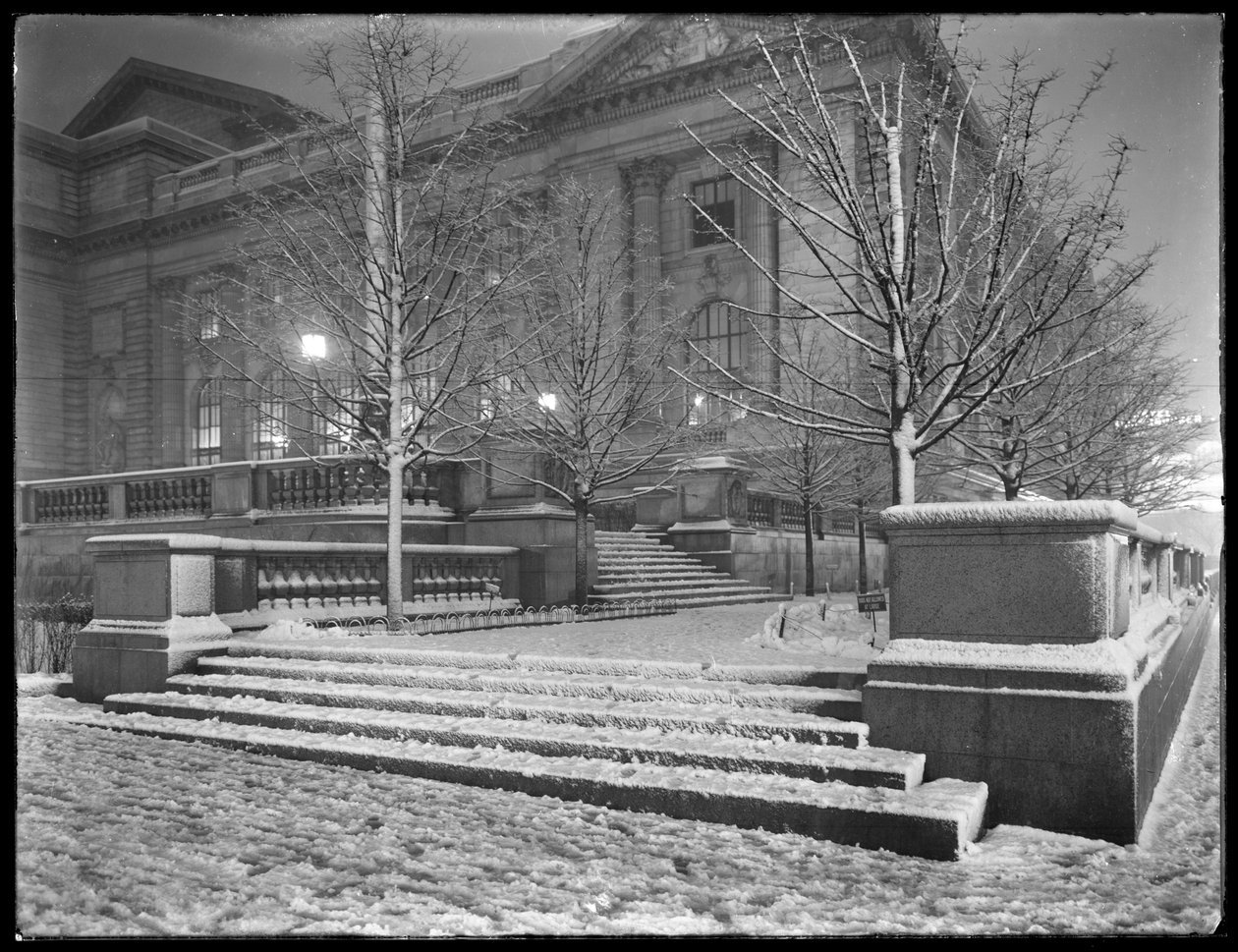 Visão noturna do canto nordeste dos degraus do lado de fora do prédio principal da Biblioteca Pública de Nova York na neve, 42nd Street e Fifth Avenue, Nova York, 6 de março de 1915 de William Davis Hassler