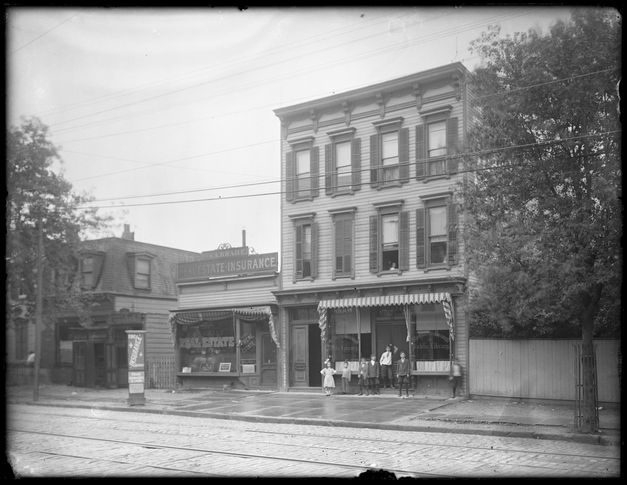Sete crianças posam em frente a um ramo não identificado da Biblioteca Pública Queens Borough, Nova York, c.1910 de William Davis Hassler