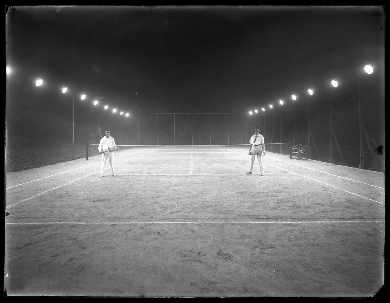 Dois jovens em quadra de tênis de argila não identificado à noite, julho de 1915 de William Davis Hassler