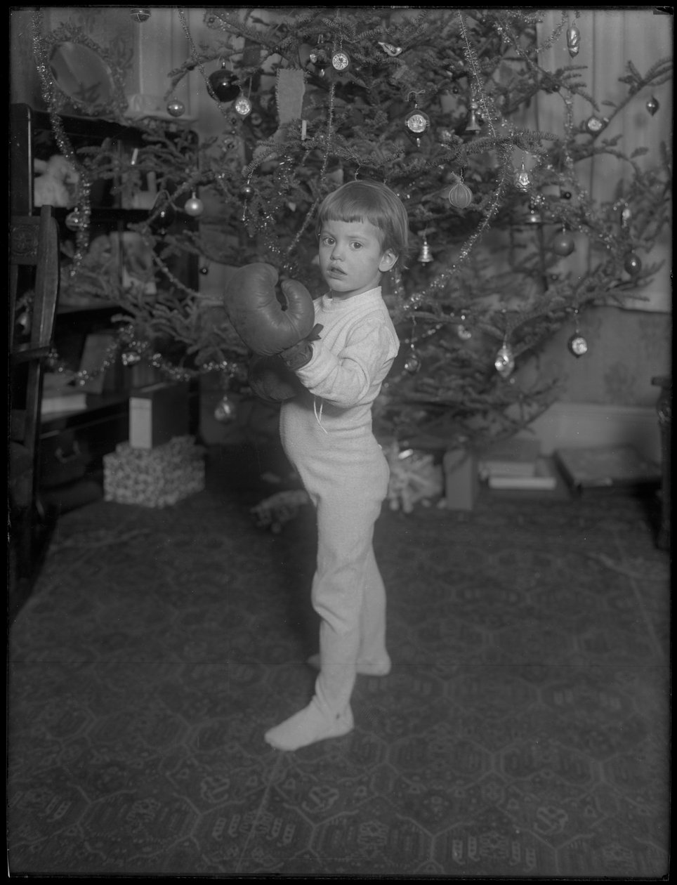 Não identificado criança em pé na frente de uma árvore de Natal com luvas de boxe, 1915-16 de William Davis Hassler