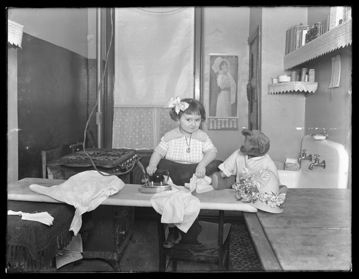 Menina não identificada, demonstrando o uso de um ferro elétrico, c.1913-14 de William Davis Hassler