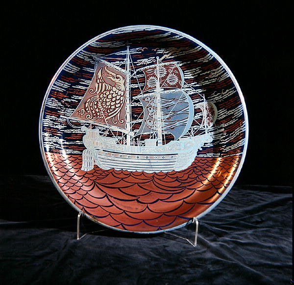 Carregador com brilho prateado, com um galeão navegando sobre um mar de brilho vermelho (cerâmica) de William de Morgan