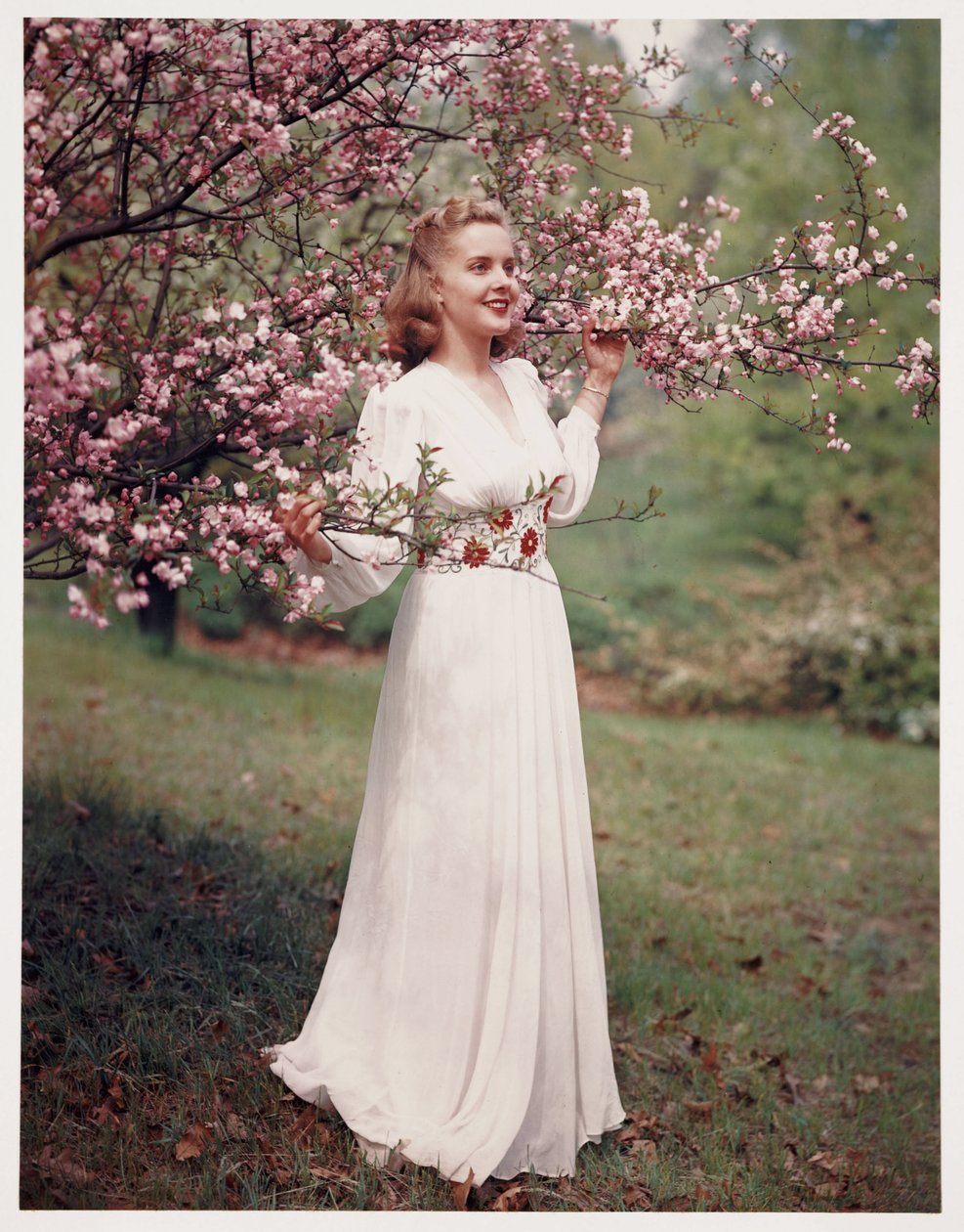 Mulher a modelar um vestido perto da flor, c 1940 de Frederick (attr. to) Barnard