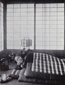 Menina a dormir entre colchas com almofadas de madeira (foto a p/b) de American Photographer (after)