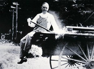 Presidente Calvin Coolidge (1873-1933) posando como fazendeiro durante umas férias em Vermont (foto a p/b) de American Photographer