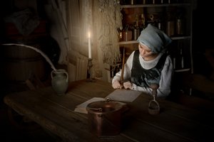 Mulher a escrever à luz de uma vela de Andrzej Lisowski