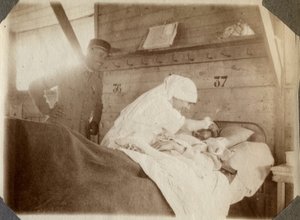 Primeira Guerra Mundial 1914-1918: enfermeira de blusa rapando um soldado (as feridas de guerra francesas jazem numa cama), em Couville, Manche, Baixa Normandia (Baixa Normandia), França. Fotografia anônima de julho de 1917. Coleção particular, Stella. de Anonymous Anonymous