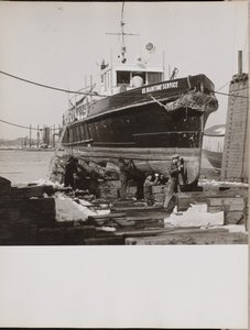 [Quatro homens reparam a parte inferior de um barco ancorado] de Arnold Eagle