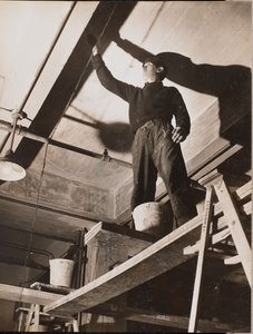 [Homem em pé num andaime de madeira pinta um teto]. de Arnold Eagle