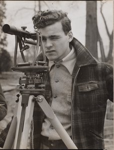 [Jovem espreita através de uma ferramenta de topógrafo]. de Arnold Eagle