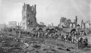 Uma seção não identificada da metralhadora australiana com os cavalos embalados que passam as ruínas do salão de pano. Observe vários caminhões de motor estacionados no fundo, 19 de outubro de 1917 de Australian Photographer