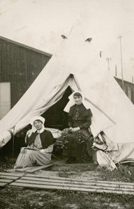 Irmã Eleanor Wibmer Jeffries e Irmã Nellie Constance Morrice (à direita) do lado de fora de sua tenda no número 3 do Hospital Geral Australiano com flores colhidas na margem do Somme, c. Junho de 1917 (foto do bw de Australian Photographer