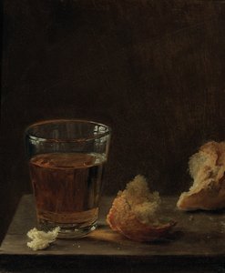 Um copo de cerveja e um pão sobre uma mesa