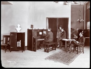 Quatro homens, um tocando um piano de H. Bruman Co., 1907 (impressão em gelatina de prata) de Byron Company