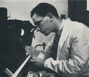 Pesquisador com microscópio testando a estrutura de uma liga de alumínio, 1941 de Cecil Beaton