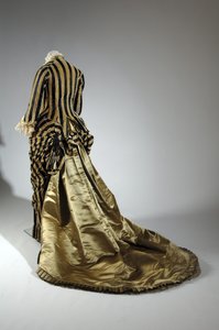 Vestido de noite, c.1884 (vista oblíqua das costas). Cetina de seda e veludo cortado, renda, borlas de fio de seda e franja. Charles Frederick Worth, França.