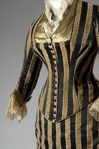 Vestido de noite, c.1884 (vista parcial oblíqua lateral). Cetina de seda e veludo cortado, renda, borlas de fio de seda e franja. Charles Frederick Worth, França.