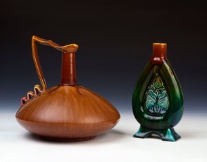 Uma jarra de cerâmica Linthorpe de forma globular comprimida com caramelo raiado, esmalte verde e carmesim e uma jarra de cerâmica Linthorpe com decoração de botões de flores perfurados e esmaltes manchados de verde, azul e marrom de Christopher Dresser