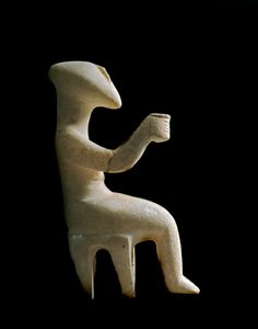 Arte das Cíclades: "estatueta sentada num banco" Ídolo de mármore incrustado com ocre. Civilização Cicládica (-3200 a -2000) Sol. 15,2 cm Athenes, Museu Nacional de Arqueologia (inv. 3910)