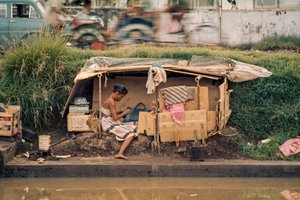 Cabana de cartão, junto a um canal de esgotos, serve de casa. Jacarta, Indonésia.