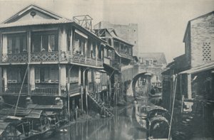 Águas contaminadas sob uma ponte que conduz a casas desagradáveis de pobreza e dor, c1935 de ENA