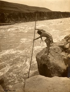 Índio Tlakluit, de pé sobre uma rocha, a pescar com rede de mergulho, c.1910 (fotografia a preto e branco) de Edward Sheriff Curtis