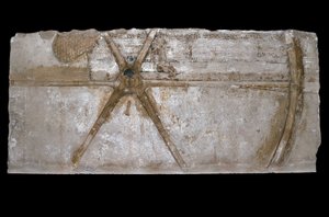 Bloco de pedra calcária esculpida e pintada com representação de uma roda de carruagem, 1353-35 aC (calcário)