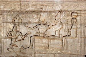 Antiguidade egípcia: relevo representando o Faraó Ramsés II diante das divindades da tríade Theban, Amon, Mut e Khonsu; Templo funerário dedicado ao Faraó Ramsés II (1279-1213 a.C.), local de Ramasseum (Ramesseum) em Luxor, Egito. de Egyptian 19th Dynasty