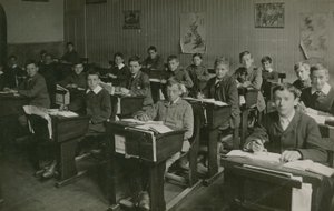 Alunos masculinos sentado atrás de suas mesas durante uma aula na escola de English Photographer