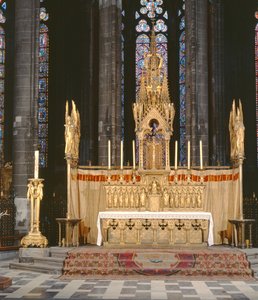 Altar alto em estilo neo-gótico, rodeado de quatro anjos carregando os instrumentos da Paixão de Cristo com um tabernáculo encimado por um pináculo elaboradamente decorado
