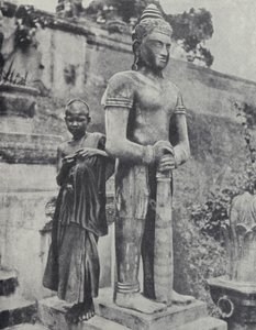 Jovem monge budista noviço ao lado de uma estátua de Buda, Indochina Francesa (foto a p/b)