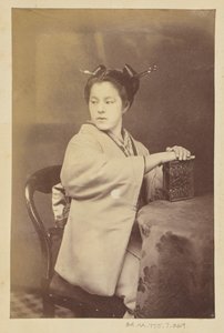 [Mulher japonesa sentada segurando um álbum de cartes-de-visite numa mesa] de Felice Beato