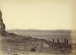 [Vista da costa com navios no horizonte e cinco figuras de pé na praia]. de Felice Beato