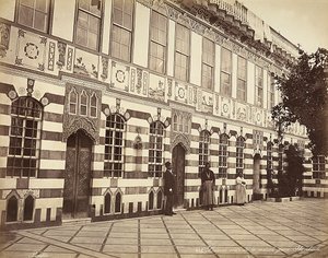 O pátio de uma casa judaica em Stambouli, na Síria, Três domésticos são mostrados perto das paredes do edifício