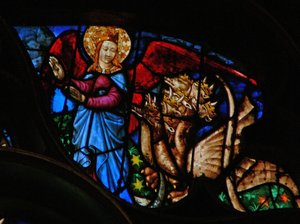 A rosácea oeste retratando uma cena do livro do Apocalipse: o dragão persegue a mãe do filho varão; mas ela tem asas para voar no deserto (12:13 14). de French School