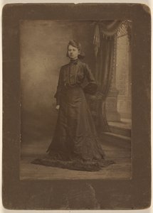 [Retrato de uma jovem mulher de vestido preto comprido, de pé] de George W. Killian