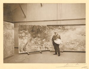 Claude Monet (1840-1926) na frente de suas pinturas 