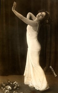 Retrato da atriz francesa Regina Badet numa pose evocativa, com um vestido branco comprido. de Henri Manuel