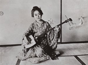 Uma gueixa tocando o Samisen (foto a p/b) de Herbert Ponting