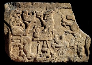 Arte Ibérica: baixo relevo representando uma cena de banquete mitológica onde um deus do submundo tem duas cabeças com a boca aberta em frente a um altar de sacrifício. Cerca de 500 a.C., vindo do túmulo de Pozo Moro, Espanha. Madrid, Museo Arqueologico Na