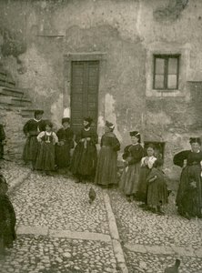 Mulheres e crianças vestindo roupas tradicionais nos degraus que levam à casa, Abruzzo, Itália de Italian Photographer