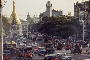 Carros antigos entopem o centro da cidade de Rangoon, capital da Birmânia. Estrada do Pagode Sule, R... de James L Stanfield
