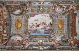 Banquete de casamento. Nas nuvens, Baco, Ariadne e Vénus, com uma figura a servir vinho, estão sentados numa mesa redonda. Os outros deuses observam de longe.