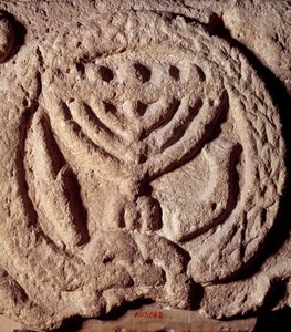 Judaísmo: elemento arquitetônico em basalto de uma sinagoga decorada com um candelabro de sete ramos (Menora ou Menorah), palma e trombeta. Do Transjordaniano. Cerca de 100 DC. Paris, Museu do Louvre de Jewish School