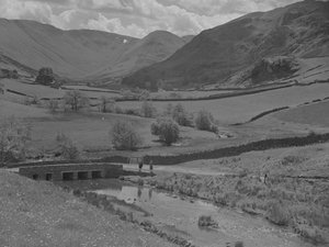 Vista de uma ponte, de um riacho, de campos e de montanhas de Joseph Hardman